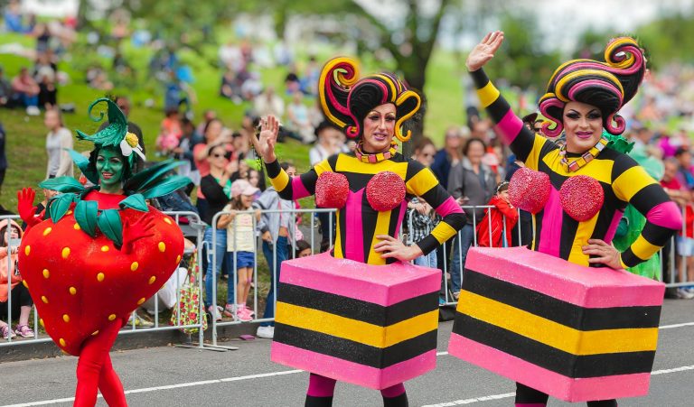 Bright costumes and lively participants in a festive outdoor parade.
