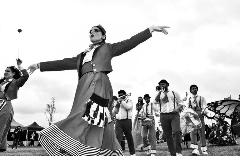 Captivating black and white photo of a lively festival parade with musicians and performers in İstanbul.